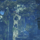 A dilapidated, overgrown stone tower stands in a forest-y ruin.